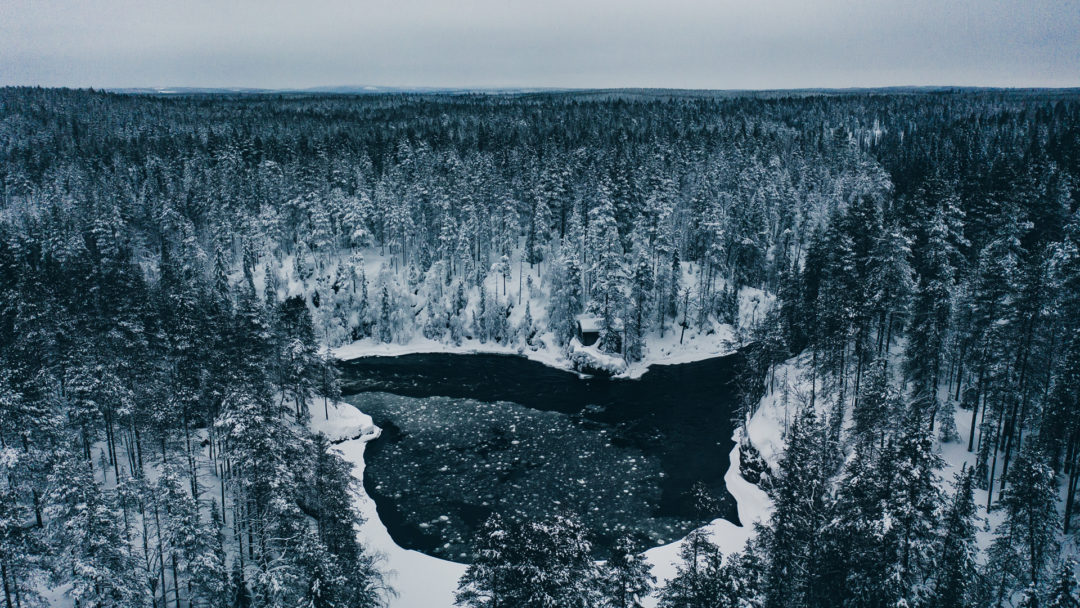 Beautiful Oulanka river in winter. The ice is spinning around in vortex in this place.